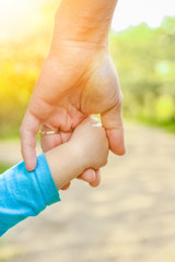 the parent holding the child's hand with a happy background