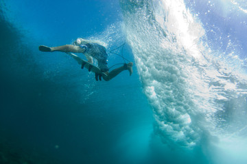 Underwater surf photography, surfer jumping off the wave