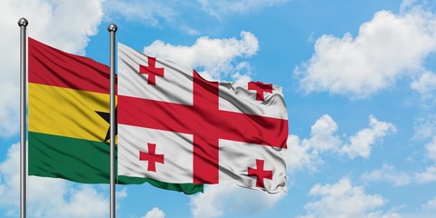 Ghana and Georgia flag waving in the wind against white cloudy blue sky together. Diplomacy concept, international relations.