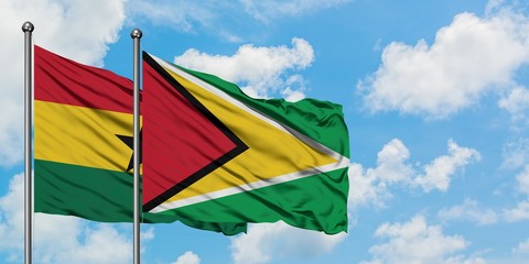 Ghana and Guyana flag waving in the wind against white cloudy blue sky together. Diplomacy concept, international relations.