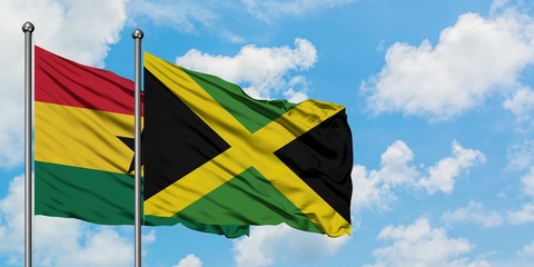 Ghana and Jamaica flag waving in the wind against white cloudy blue sky together. Diplomacy concept, international relations.