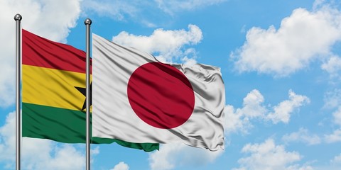 Ghana and Japan flag waving in the wind against white cloudy blue sky together. Diplomacy concept, international relations.