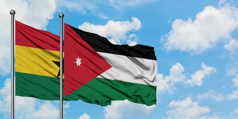 Ghana and Jordan flag waving in the wind against white cloudy blue sky together. Diplomacy concept, international relations.