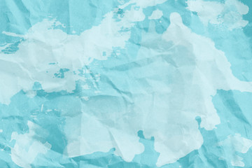 creative idea for background. crumpled blue paper with white paint splashes