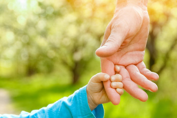 the parent holding the child's hand with a happy background