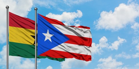 Ghana and Puerto Rico flag waving in the wind against white cloudy blue sky together. Diplomacy concept, international relations.