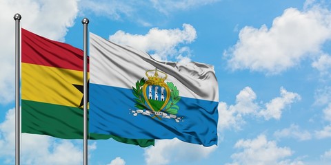 Ghana and San Marino flag waving in the wind against white cloudy blue sky together. Diplomacy concept, international relations.