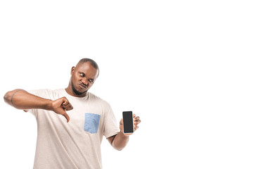 dissatisfied african american man holding smartphone with blank screen and showing thumb down isolated on white
