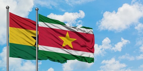 Ghana and Suriname flag waving in the wind against white cloudy blue sky together. Diplomacy concept, international relations.
