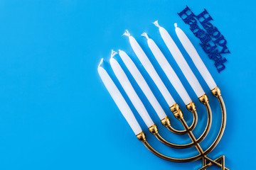 Jewish Hanukkah menorah on blue background. Top view. Copy space	
