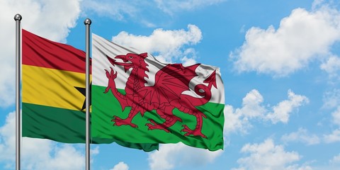 Ghana and Wales flag waving in the wind against white cloudy blue sky together. Diplomacy concept, international relations.