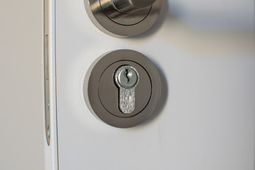 modern lock with keyhole in white door closeup