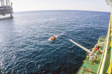Fast rescue craft being deploy from a construction barge during an emergency drill excercise at oil...