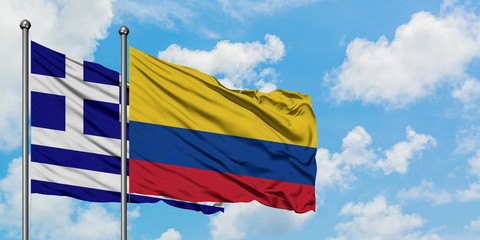 Greece and Colombia flag waving in the wind against white cloudy blue sky together. Diplomacy concept, international relations.