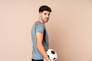 Young man over isolated background with soccer ball