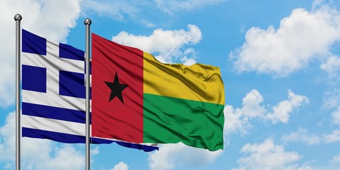 Greece and Guinea Bissau flag waving in the wind against white cloudy blue sky together. Diplomacy concept, international relations.