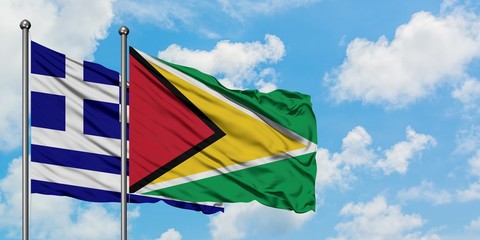 Greece and Guyana flag waving in the wind against white cloudy blue sky together. Diplomacy concept, international relations.