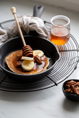Pancakes with banana, walnuts and honey. Morning concept