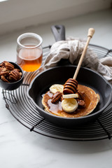 Pancakes with banana, walnuts and honey. Morning concept