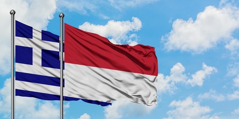 Greece and Monaco flag waving in the wind against white cloudy blue sky together. Diplomacy concept, international relations.