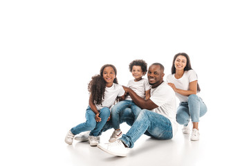 happy african american family smiling at camera while sitting on white background