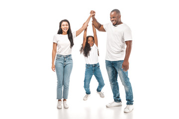 Obraz premium cheerful african american child hanging on hands of parents on white background