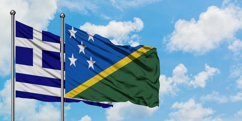 Greece and Solomon Islands flag waving in the wind against white cloudy blue sky together. Diplomacy concept, international relations.