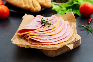 Close up fresh hum meat for sandwiches, dark board with vegetables on background.