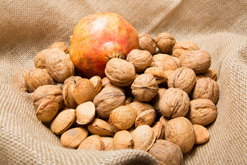 Autumn still life with nuts and almonds and pomegranate on brown background