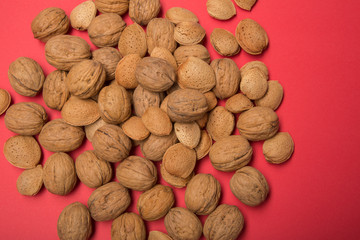 Still life with nuts and almonds on red background