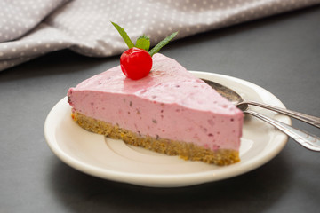 Cheesecake slice with berries, pink cheesecake isolated on dark background, dessert or breakfast. Sweet food.