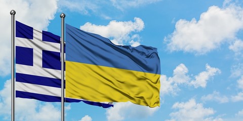 Greece and Ukraine flag waving in the wind against white cloudy blue sky together. Diplomacy concept, international relations.
