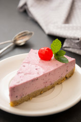 Cheesecake slice with berries, pink cheesecake isolated on dark background, dessert or breakfast. Sweet food.