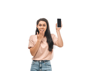 shocked african american woman holding smartphone with blank screen and covering mouth with hand isolated on white