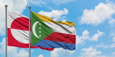 Greenland and Comoros flag waving in the wind against white cloudy blue sky together. Diplomacy concept, international relations.