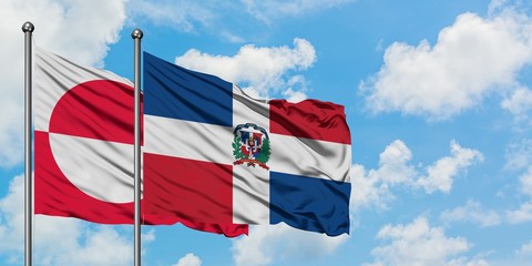 Greenland and Dominican Republic flag waving in the wind against white cloudy blue sky together. Diplomacy concept, international relations.