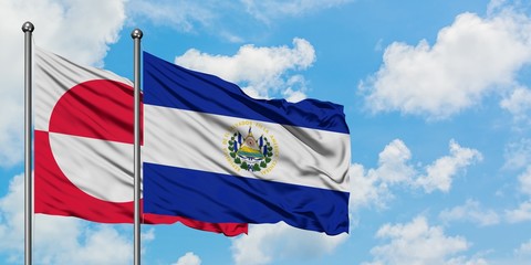 Greenland and El Salvador flag waving in the wind against white cloudy blue sky together. Diplomacy concept, international relations.