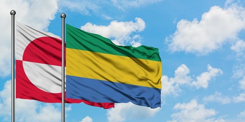 Greenland and Gabon flag waving in the wind against white cloudy blue sky together. Diplomacy concept, international relations.