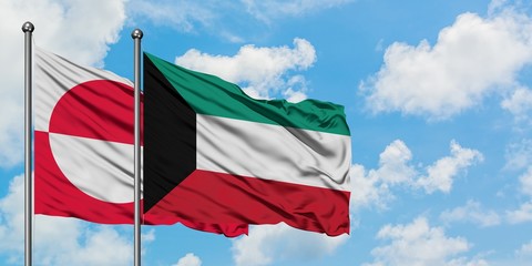 Greenland and Kuwait flag waving in the wind against white cloudy blue sky together. Diplomacy concept, international relations.