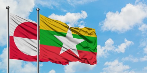 Greenland and Myanmar flag waving in the wind against white cloudy blue sky together. Diplomacy concept, international relations.