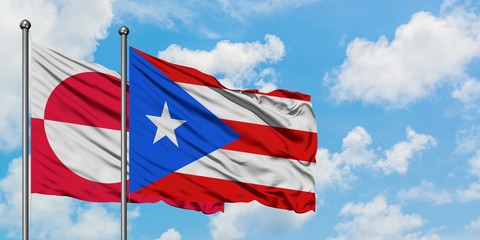 Greenland and Puerto Rico flag waving in the wind against white cloudy blue sky together. Diplomacy concept, international relations.