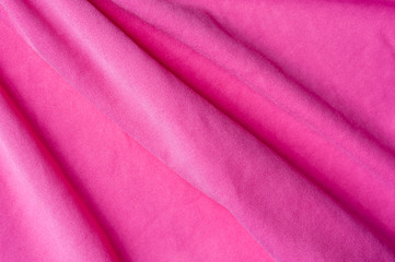 Fototapeta na wymiar Closeup fragment of crumpled pink polyester fabric