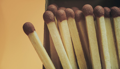 Close up Beautiful wooden matches  on a yellow background texture. Macro photography view.