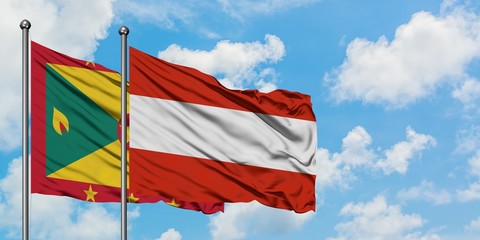 Grenada and Austria flag waving in the wind against white cloudy blue sky together. Diplomacy concept, international relations.