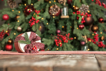 Christmas background, a gift lies on a wooden board on the background of a Christmas tree