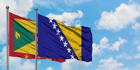 Grenada and Bosnia Herzegovina flag waving in the wind against white cloudy blue sky together....