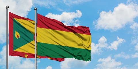 Grenada and Bolivia flag waving in the wind against white cloudy blue sky together. Diplomacy concept, international relations.