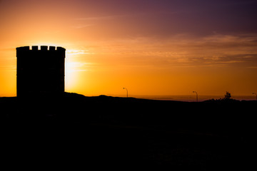 Obraz premium Silhouette of tower eclipsing the sun at sunset