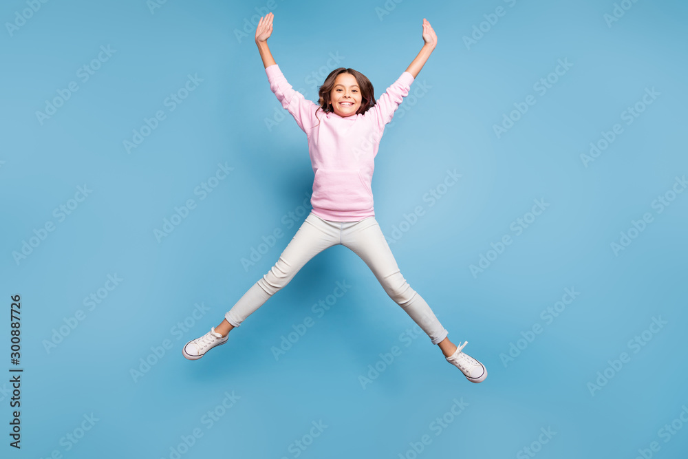 Poster Full length body size photo of cheerful positive toothy beaming girl stretching her arms and legs pink shaping star jumping up isolated pastel blue color background