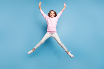 Obraz premium Pełnowymiarowe zdjęcie rozmiaru ciała wesołej pozytywnej, rozpromienionej zębatej dziewczyny rozciągającej ręce i nogi różowa kształtowana gwiazda skacząca w górę izolowane pastelowe niebieskie tło